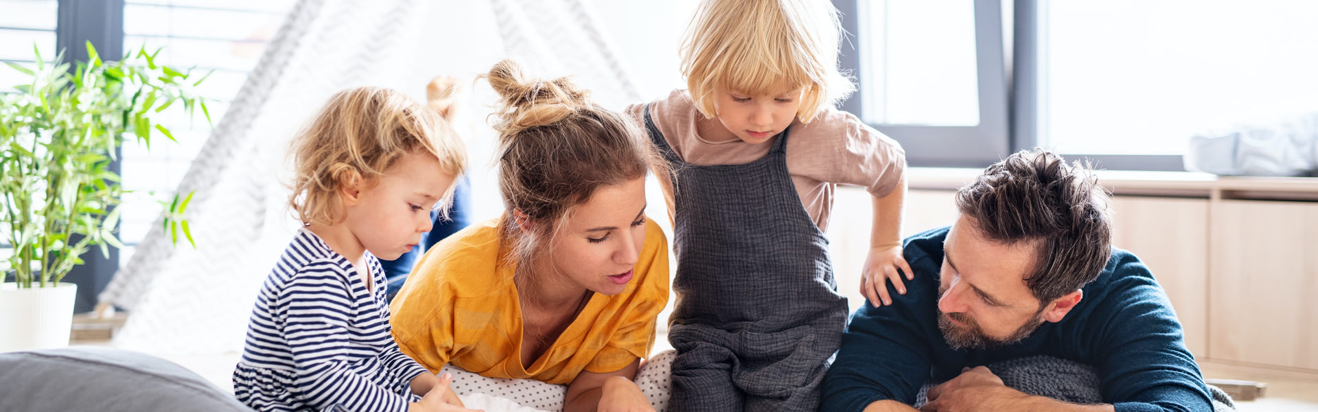 Husband and wife reading with their children